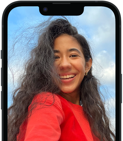 旁白功能正描述在 iPhone 上的相片，並顯示語音朗讀的文字輸出「一個穿著紅襯衫的人在多雲的藍天前擺姿勢拍照。」