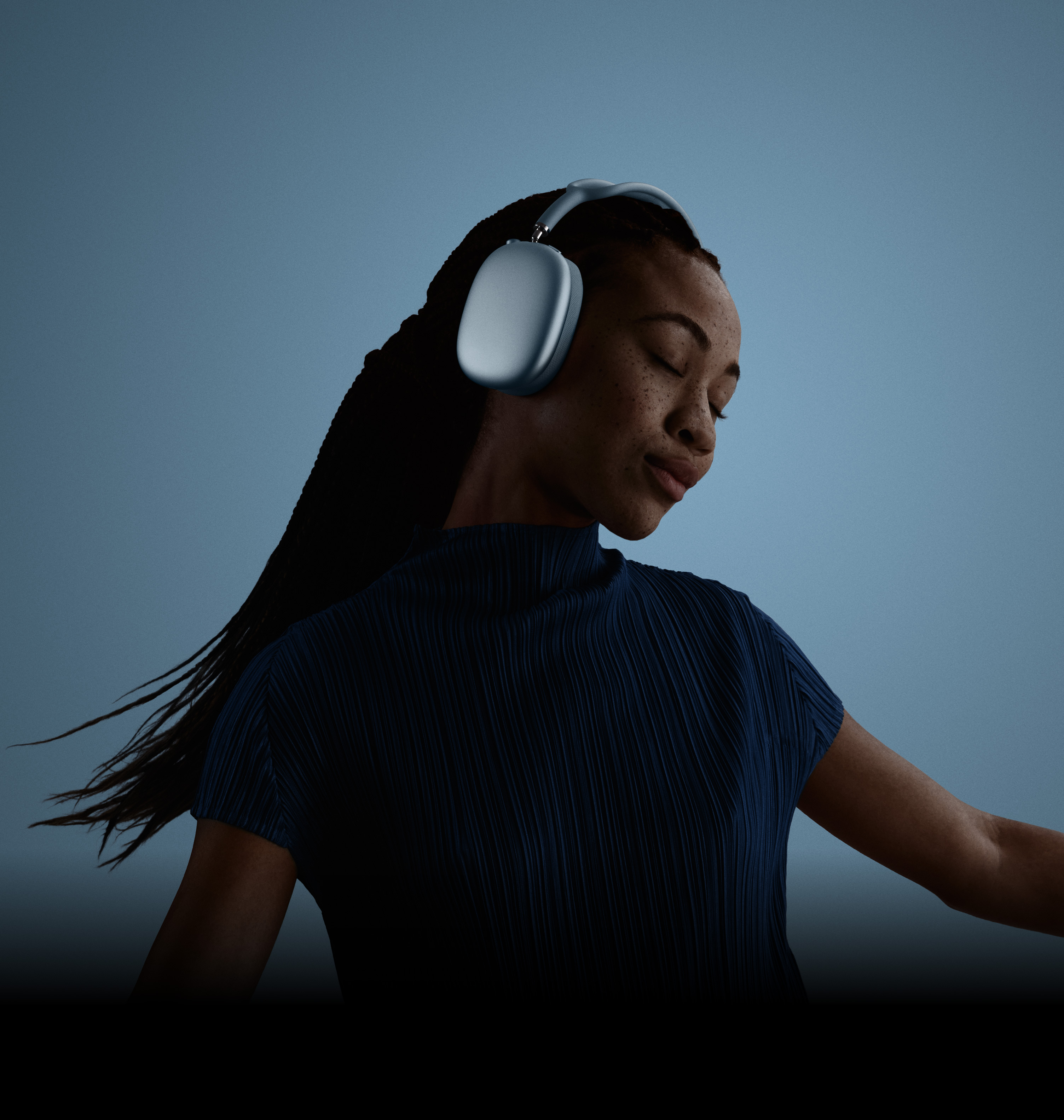 Seorang wanita dengan mata tertutup, dan kepala dimiringkan ke kiri, mengenakan AirPods Max.