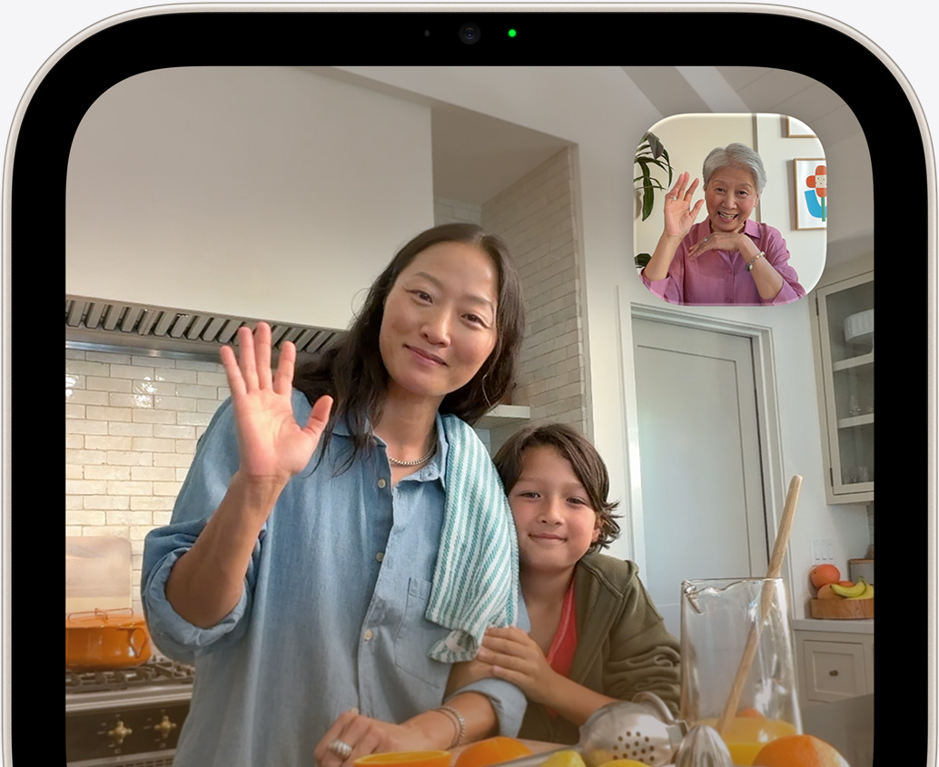 Apple HomeView, screen shows a FaceTime video call with a woman and child in a kitchen, and an older woman waving in the inset window