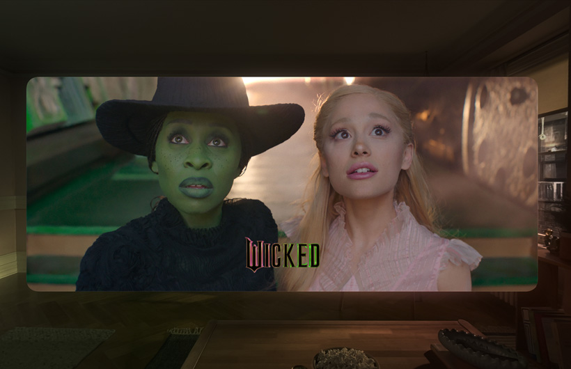 Two main characters from the film Wicked in the Apple TV app on Apple Vision Pro.
