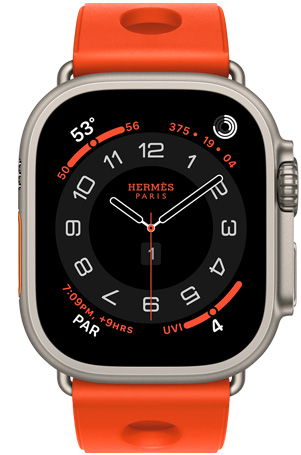 Apple Watch Hermès Ultra 3, cadran analogique Circulaire, (aiguilles des heures, des minutes et des secondes, complications: Météo, anneaux Activité, heure de Paris et Indice UV), boîtier en titane, finition naturelle, côté droit, Digital Crown, bouton latéral en saillie, associée au bracelet Scub’H Diving, orange néon (orange vif), caoutchouc moulé, découpes circulaires centrées