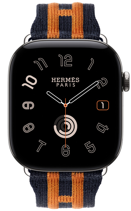 Apple Watch Hermès Series 12, cadran analogique Radial, (aiguilles des heures, des minutes et des secondes, complications : date, anneaux Activité), boîtier en titane, argent, côté droit, Digital Crown, bouton latéral en saillie, associée au bracelet Rocabar Club, Bleu Nuit/Orange, mailles tricotées bleu foncé avec rayures orange en relief ornées du logo H d’Hermès