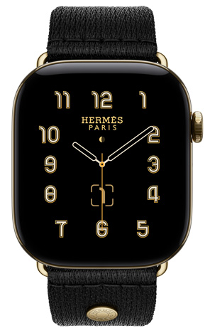 Apple Watch Hermès Series 12, cadran analogique Clou de Selle (aiguilles des heures, des minutes et des secondes, complications : calendrier lunaire, date), boîtier en titane, or brillant, côté droit, Digital Crown, bouton latéral, associée au bracelet Clou de Selle Satin Noir, tissu satiné noir avec attaches or brillant assorties au boîtier de la montre