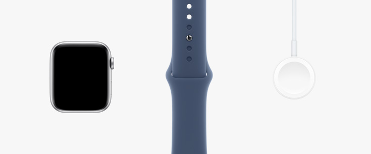 Alinhados em fila: imagem da parte da frente do Apple Watch SE, uma pulseira esportiva estelar e cabo magnético para recarga com conector USB-C.