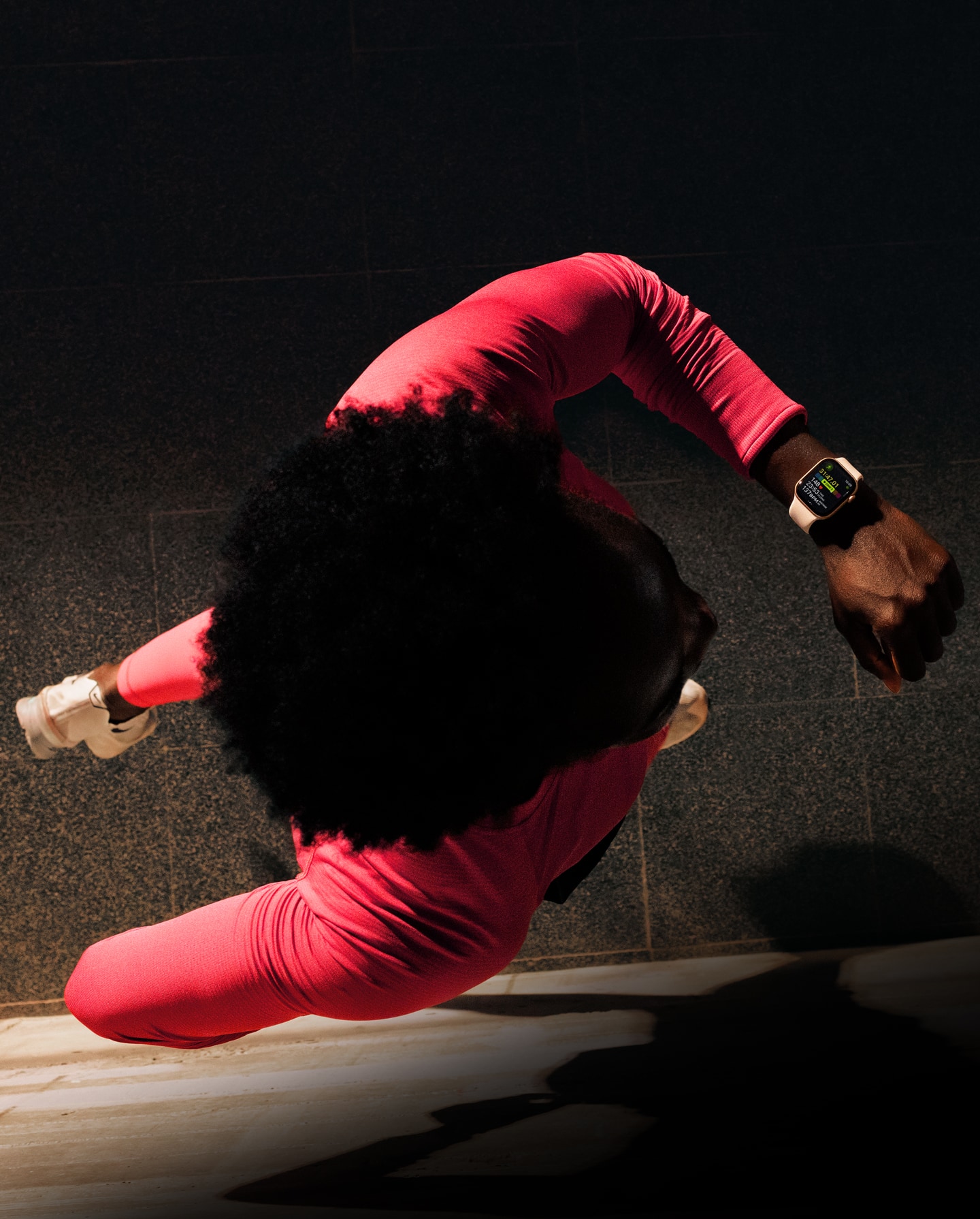 Bėgiojantis asmuo, tikrinantis treniruotės eigą „Apple Watch Series 11“ programoje „Treniruotė“