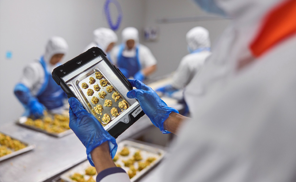 Ein:e Mitarbeiter:in führt mit dem iPad eine Qualitätskontrolle durch.