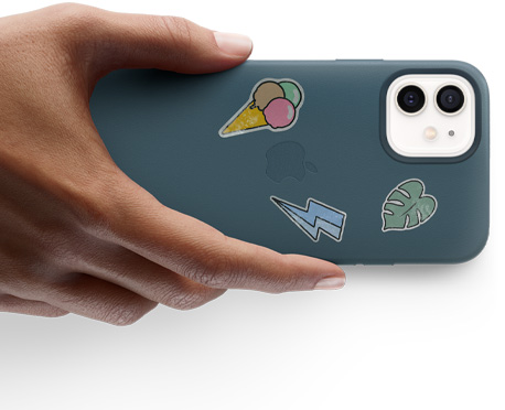 يد تحمل iPhone 12 مع ملصقات.