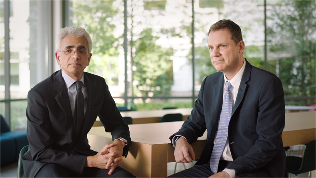 Deux personnes en complet assises à une table.