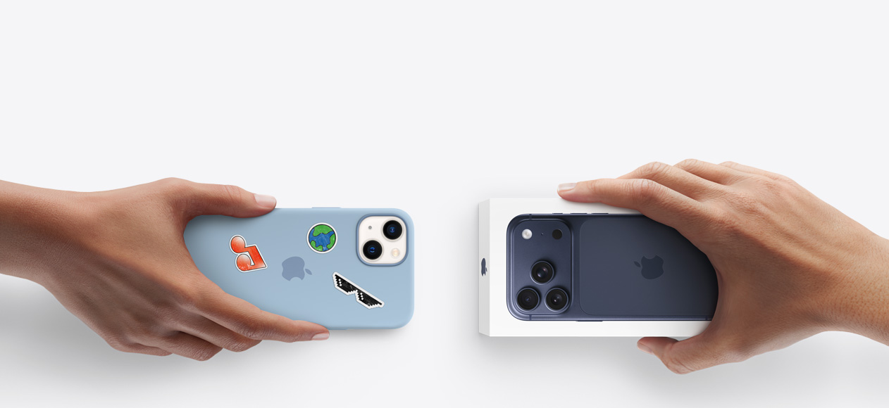 Side-by-side, hand holding iPhone 13 in silicon case with stickers on back exterior, trade-in with hand holding new iPhone box for iPhone 17 Pro