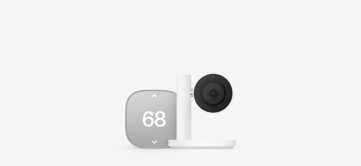 Apple Home Collection smart home accessories, including thermostat, silver color, displaying temperature of 68 degrees, and camera, black color, mounted on a white stand