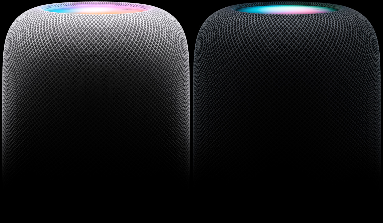 Side view of two HomePod speakers positioned side by side — the left speaker is White, the right speaker is Midnight