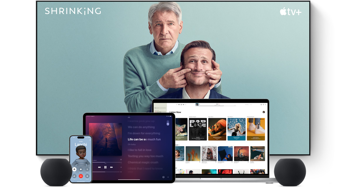 Large flat screen television showing two male characters from the Apple TV+ series shrinking. A MacBook Pro, an iPad, an iPhone, and a Space Gray HomePod mini are arranged in front.