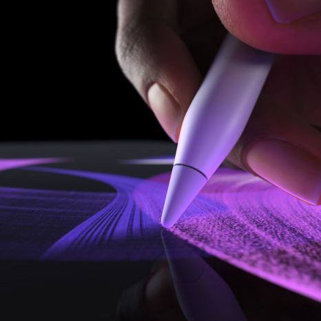 白色 Apple Pencil Pro 側面外觀，一隻手正使用它繪製一條色彩生動的藍色筆刷線條