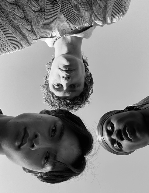 Selfie de grupo de três pessoas que se encontram a diferentes distâncias da câmara. Esta fotografia foi tirada com a câmara TrueDepth.
