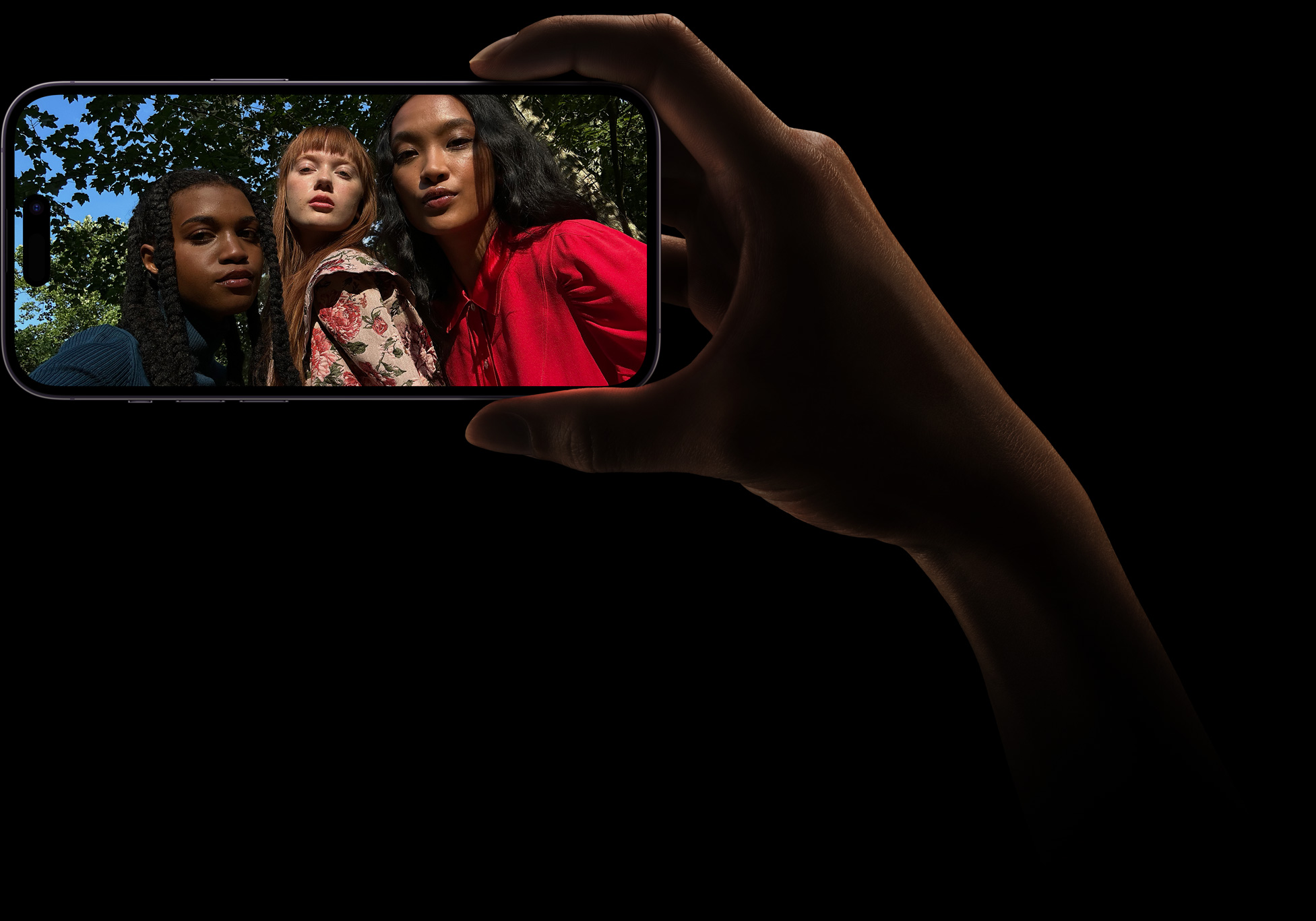 Selfie de grupo com três mulheres a posar juntas. Esta fotografia foi tirada com a câmara TrueDepth.
