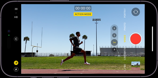 An iPhone 14 Pro screen containing a still image of an Action mode shot, which captures a person running through a sports field.