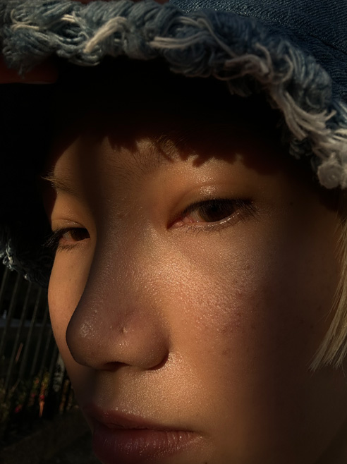 Selfie close-up wajah seorang perempuan, yang memperlihatkan detail luar biasa, diambil dengan kamera TrueDepth.
