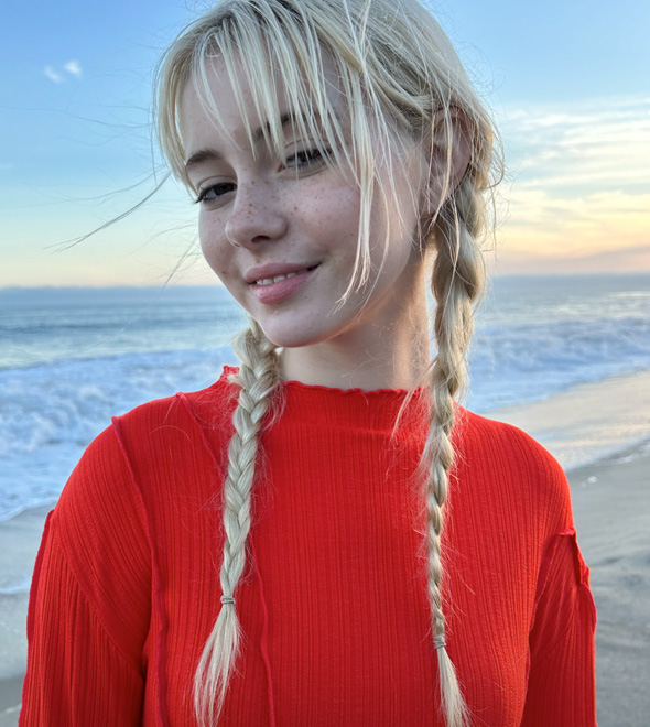 A vibrant portrait of someone in a red sweater in front of the ocean, taken with the TrueDepth camera