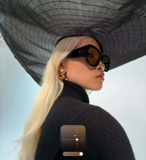 Een portretfoto van een vrouw die een hoed met een brede rand op heeft om de Fotografische Stijl Helder te demonstreren. Foto’s die bij weinig licht of in de Nachtmodus worden gemaakt, worden met deze stijl helderder