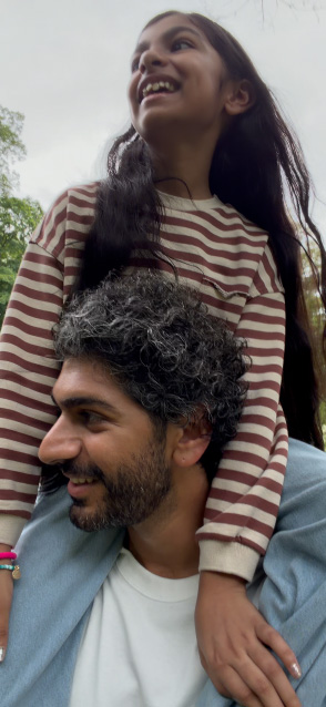 iPhone 17 screen demonstrating stabilised video recording as man carries young girl on his shoulders