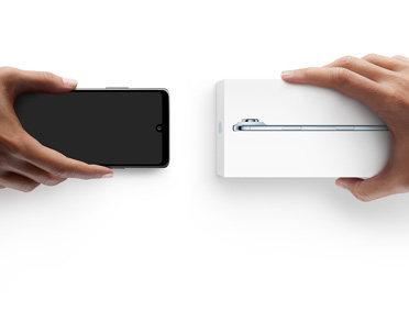 兩隻手在交換電話，左邊手拿著一部沒有包裝盒的 Android，右邊手拿著一部在包裝盒內的全新 iPhone Air。