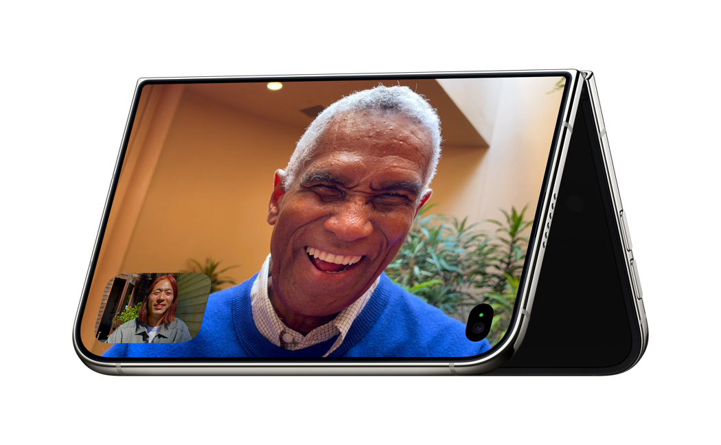 iPhone Duo가 화면이 밖을 향하도록 역 V자 형태를 이루며 가장자리로 세워져 있고, 스탠바이 모드에서 FaceTime 앱이 열려 있는 모습