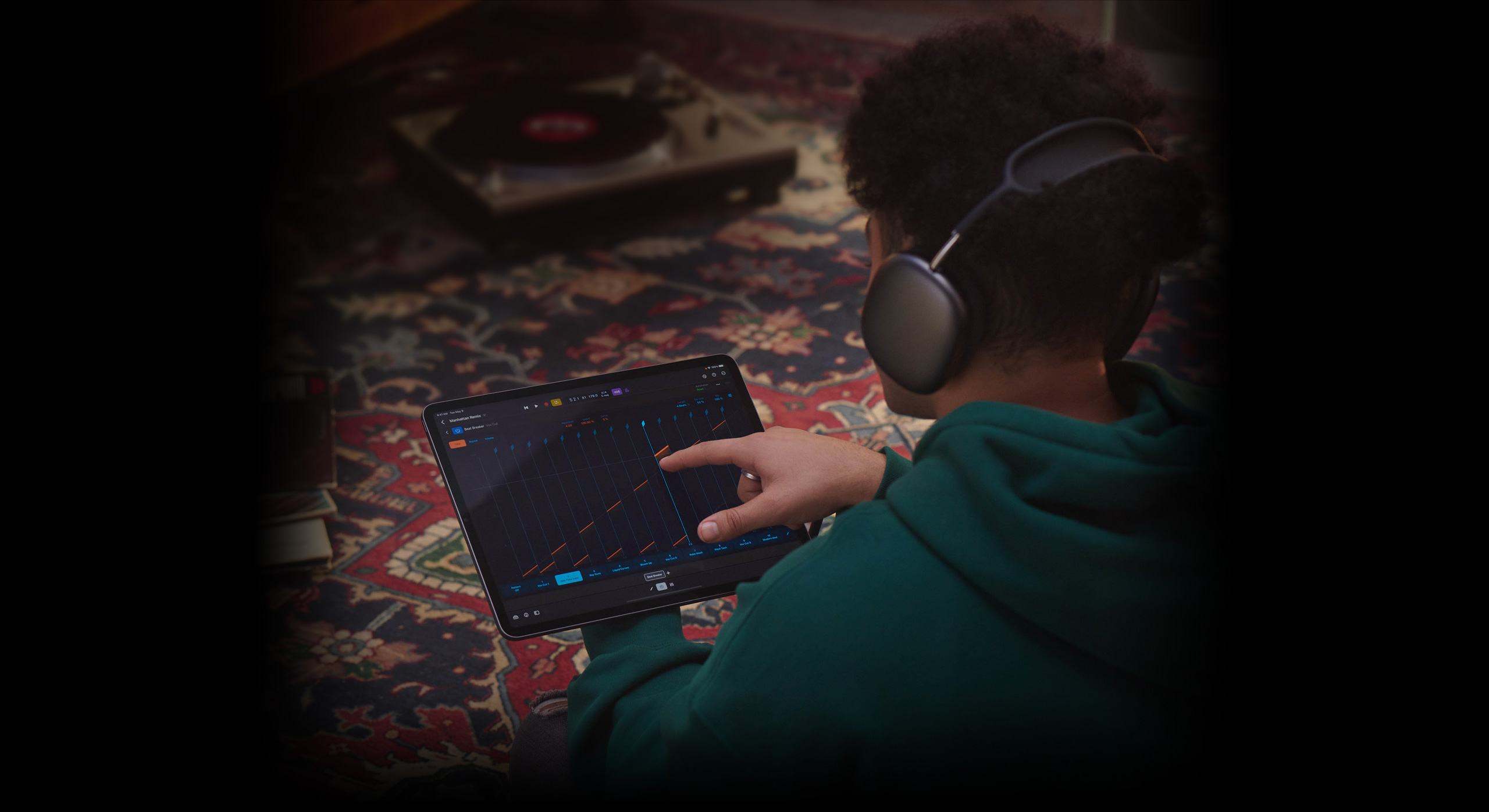 A person wearing headphones touches an iPad Pro screen to create a beat in Logic Pro for iPad.