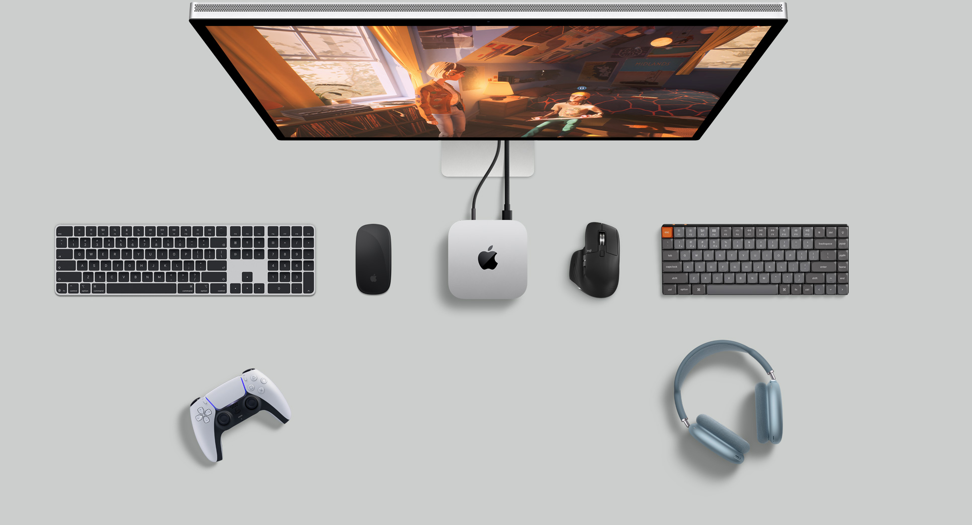 Top view of Mac mini in a desk setup with Studio Display, wireless keyboards, wireless mice, a gaming controller and AirPods Max
