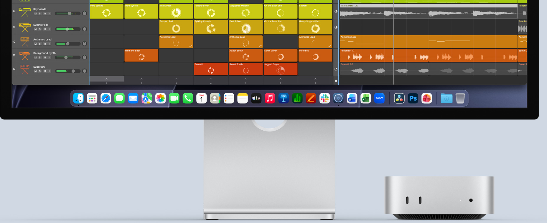 Mac mini front, tucked under Studio Display, with Logic Pro interface on screen and productivity apps in Dock at the bottom