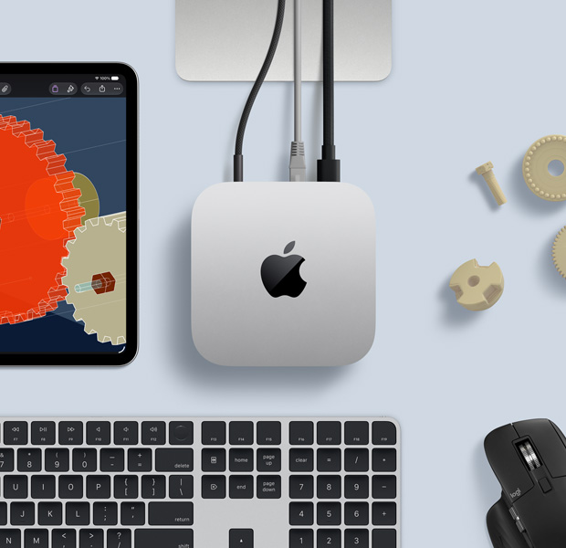 iPad displaying detailed STEM objects, Mac mini central with power cable attached, Studio Display stand partially visible, connected via USB-C, Magic Keyboard with Touch ID and Logitech mouse
