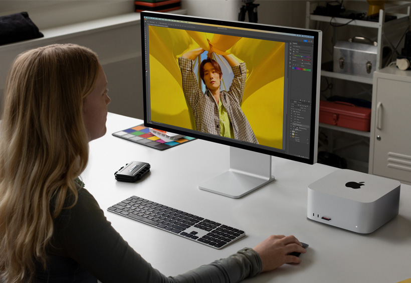 攝影師使用 Mac Studio 連接一部 Studio Display 進行工作。