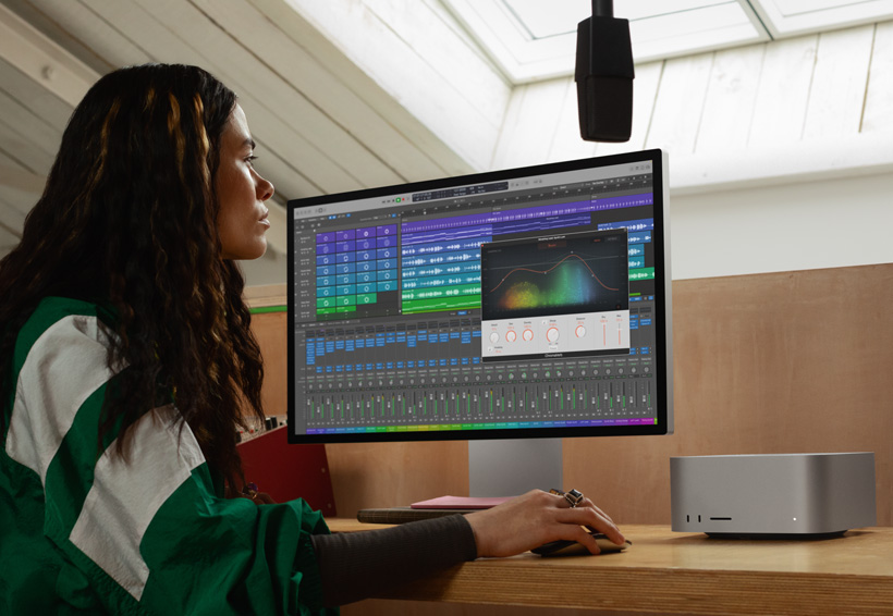 Teknisi suara yang bekerja menggunakan Mac Studio dan Studio Display