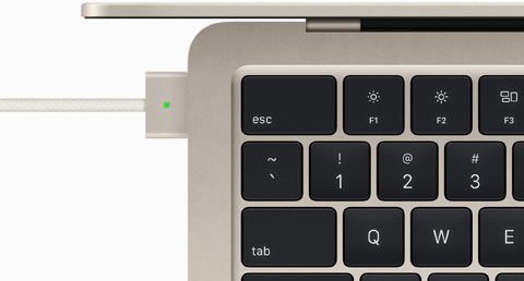 展示 MagSafe 充電線連上星光色 MacBook Air 的俯視圖