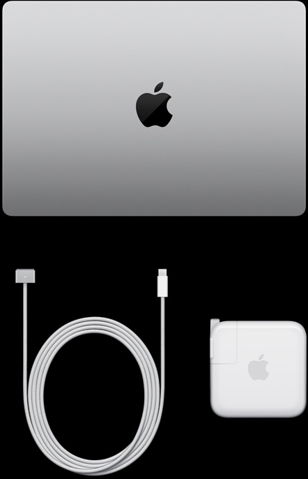 Un MacBook Pro, couleur argent, dessus, fermé, à côté d’un câble de recharge et d’un adaptateur