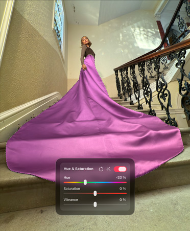 Foto de una mujer con un sofisticado vestido rosa subiendo una escalera en una casa elegante, con la ventana de tono y saturación abierta.