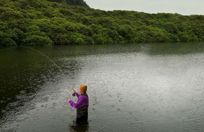 Foto de una mujer pescando con mosca en un lago, herramienta de Pixelmator Pro que elimina objetos no deseados